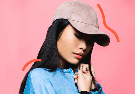 girl with baseball cap on pink background